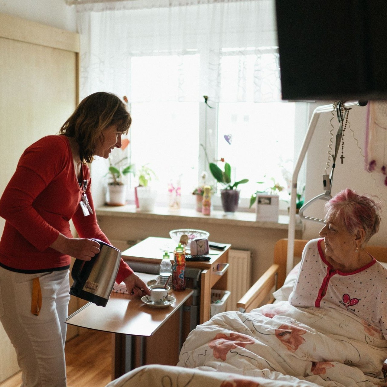 A hot drink brought to an older woman’s bedside