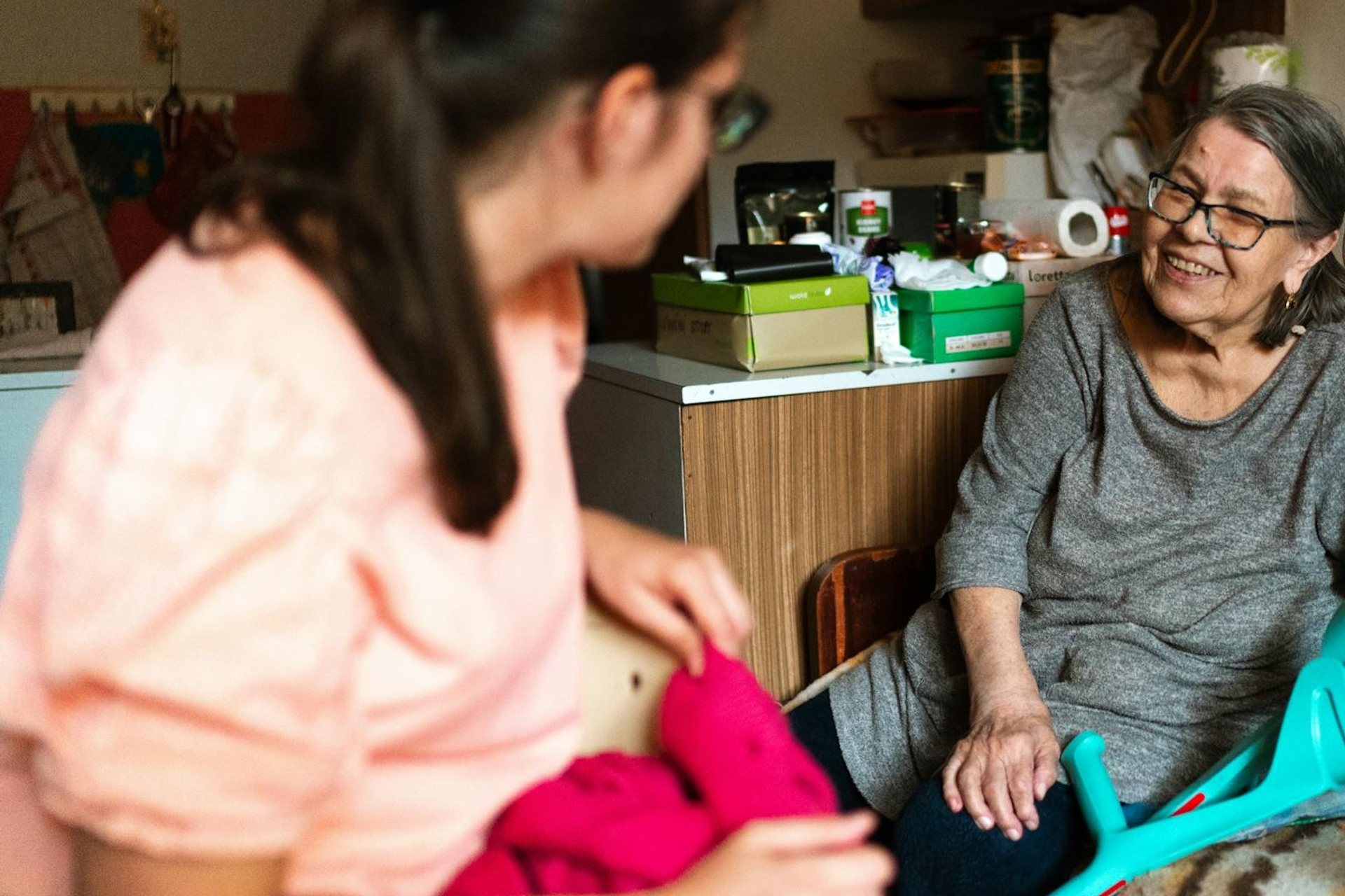 An older woman laughing during a caregiver’s visit